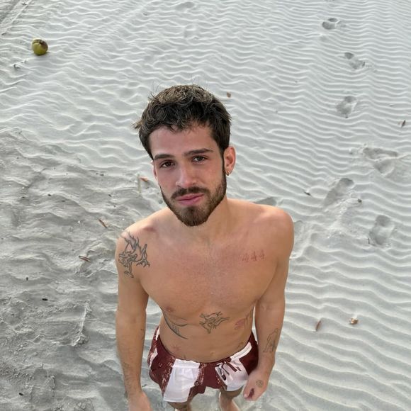 Na primeira foto compartilhada por João Guilherme, ele aparece sozinho, sem camisa, olhando para a câmera usando uma bermuda vinho e branca.