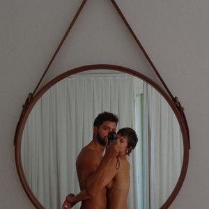 Casal publicou uma sequência de fotos completamente pelados, incluindo essa em frente ao espelho tapando suas intimidades com uma tarja