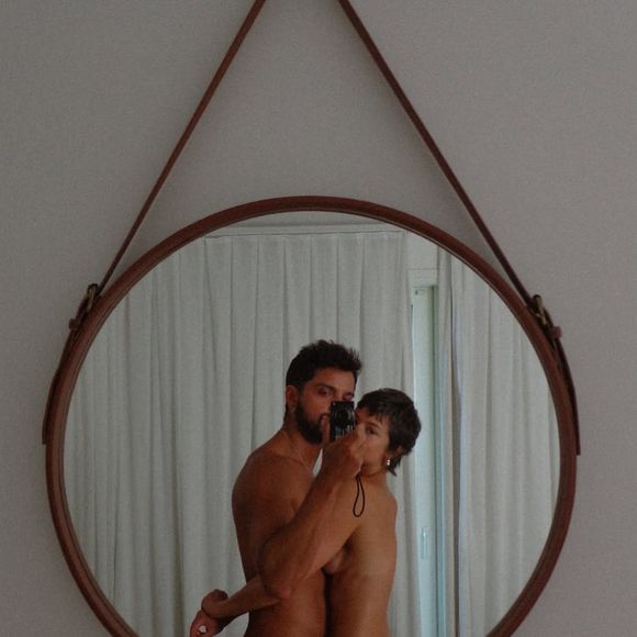 Casal publicou uma sequência de fotos completamente pelados, incluindo essa em frente ao espelho tapando suas intimidades com uma tarja