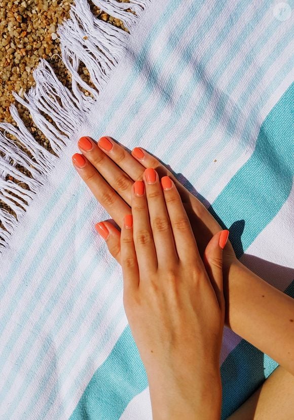 O esmalte laranja deixa a unha mais alegre