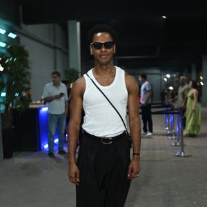 Dan Ferreira esbanjou estilo e atleticismo ao combinar uma regata branca básica perfeitamente ajustada a uma calça social preta de cintura alta e caimento amplo. O ator finalizou o visual com um cinto preto de fivela prateada, sapatos pretos elegantes, bolsa transversal e óculos de sol pretos marcantes. A composição trouxe uma estética effortless chic impecável