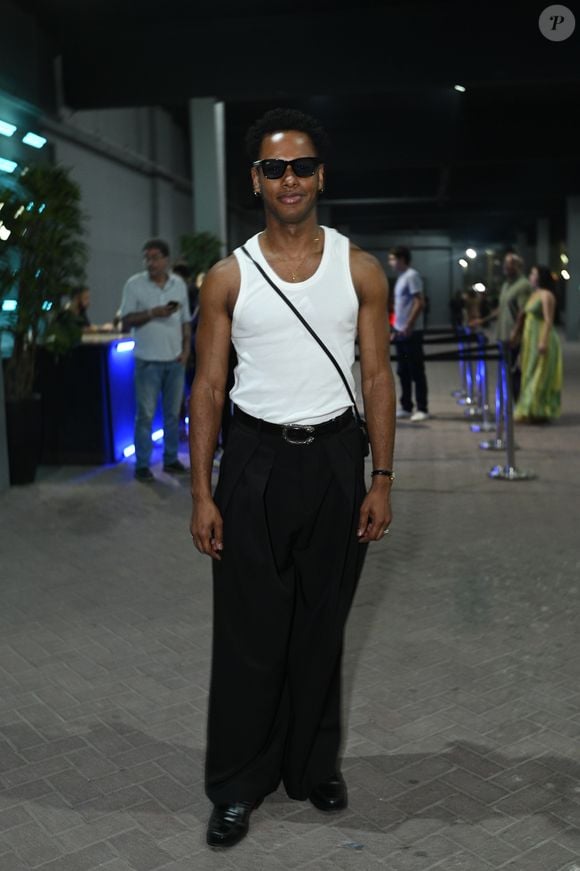 Dan Ferreira esbanjou estilo e atleticismo ao combinar uma regata branca básica perfeitamente ajustada a uma calça social preta de cintura alta e caimento amplo. O ator finalizou o visual com um cinto preto de fivela prateada, sapatos pretos elegantes, bolsa transversal e óculos de sol pretos marcantes. A composição trouxe uma estética effortless chic impecável
