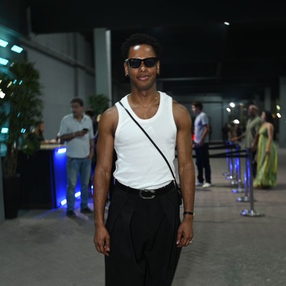 Dan Ferreira esbanjou estilo e atleticismo ao combinar uma regata branca básica perfeitamente ajustada a uma calça social preta de cintura alta e caimento amplo. O ator finalizou o visual com um cinto preto de fivela prateada, sapatos pretos elegantes, bolsa transversal e óculos de sol pretos marcantes. A composição trouxe uma estética effortless chic impecável