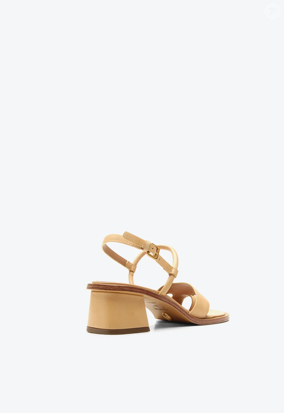 O modelo possui salto bloco e um detalhe metalizado no dedo, elemento que acrescenta um toque de sofisticação ao design minimalista, estilo vinculado a Carolyn Bessette-Kennedy