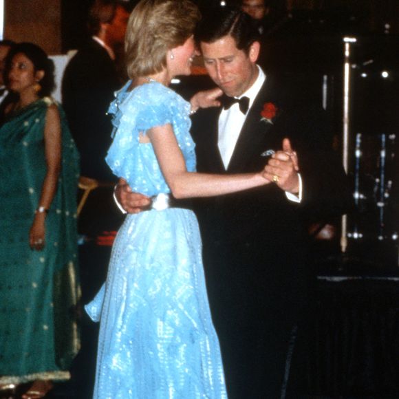 O Príncipe Charles e Diana, Princesa de Gales, dançam durante um jantar de gala no Hotel Wentworth, em Sydney, em 28 de março de 1983. Ela veste um modelo azul-claro com cinto prateado, assinado por Bruce Oldfield e o metalizado foi o toque de luz constante nos pés da princesa.