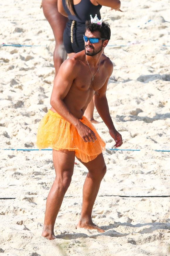 Rodrigo Simas surge com saia plissada laranja e coroa de princesa em aula de vôlei com amigos