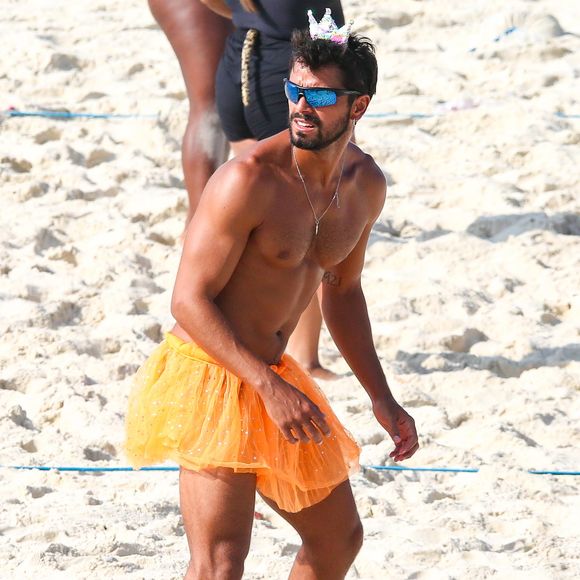 Rodrigo Simas surge com saia plissada laranja e coroa de princesa em aula de vôlei com amigos