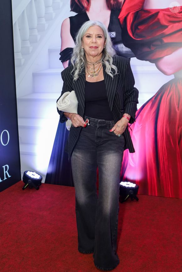 Exibindo um estilo urbano e sofisticado, Astrid Fontenelle combinou uma t-shirt preta básica com um blazer de alfaiataria em risca-de-giz de modelagem oversized. A parte inferior é composta por uma calça jeans wide leg em lavagem cinza estonada. O visual ganha personalidade através do mix de colares em diferentes comprimentos e materiais, além de uma clutch grande em couro branco sob o braço