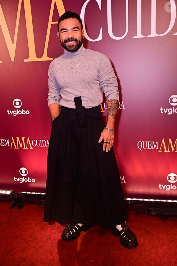Mauro Sousa: rompendo com o tradicional, Mauro optou por uma calça de cintura altíssima e modelagem ampla que remetia ao corte oriental, amarrada por uma faixa frontal. Na parte superior, uma gola alta cinza ajustada trazia sobriedade, enquanto as sandálias pretas de estilo fisherman com meias brancas davam o toque final de ousadia fashionista