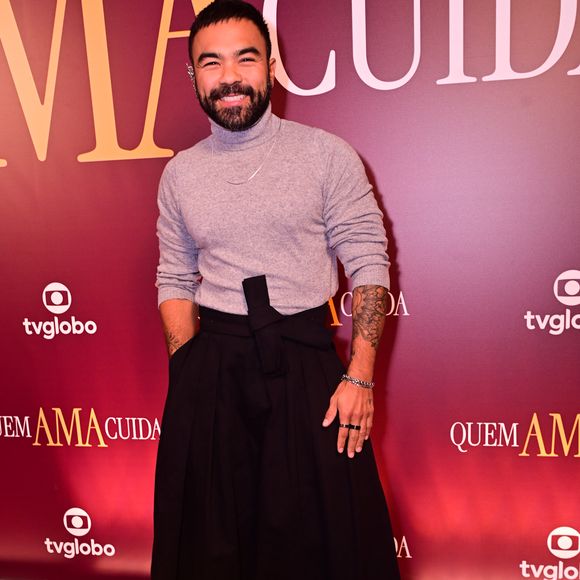 Mauro Sousa: rompendo com o tradicional, Mauro optou por uma calça de cintura altíssima e modelagem ampla que remetia ao corte oriental, amarrada por uma faixa frontal. Na parte superior, uma gola alta cinza ajustada trazia sobriedade, enquanto as sandálias pretas de estilo fisherman com meias brancas davam o toque final de ousadia fashionista