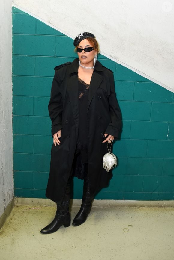 Rita Carreira: exala atitude fashionista ao ostentar um trench coat preto alongado com ombreiras marcadas sobreposto a um vestido estilo slip dress com decote em renda preta. Os acessórios roubam a cena com uma boina cravejada de pedrarias, óculos de sol pretos no estilo cat-eye, brincos e gargantilha brilhantes, botas de couro até o joelho e uma impactante bolsa esférica prateada com franjas reluzentes