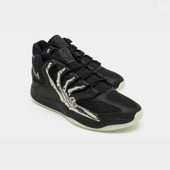 O Nike KD 18 'Halloween' celebra a temporada assustadora com um visual preto e um desenho de mão esquelética na lateral. O modelo exclusivo de Kevin Durant também conta com solado de borracha que brilha no escuro