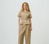 Uma calça de alfaiataria bege é uma opção versátil para variar os looks de trabalho na primavera