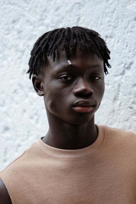 A trajetória de Mouhamed Diop na moda começou de forma inesperada: o jovem senegalês foi notado por um agente enquanto trabalhava como vendedor ambulante na praia de Ipanema