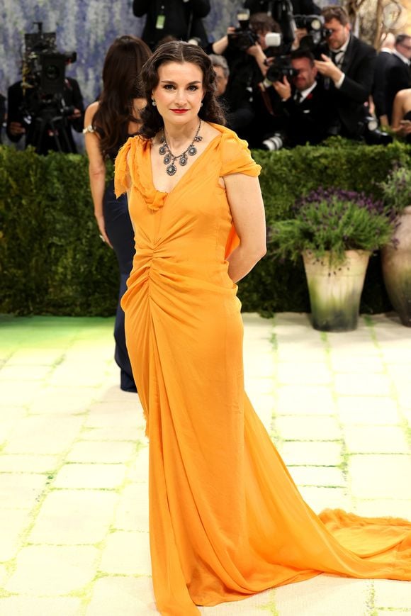 Chloe Malle, atual editora da Vogue US, optou por um vestido amarelo-alaranjado drapeado na região do umbigo em uma escolha mais discreta para o Met Gala 2026, realizado nesta segunda-feira (4) sob o tema 'Costume Art'