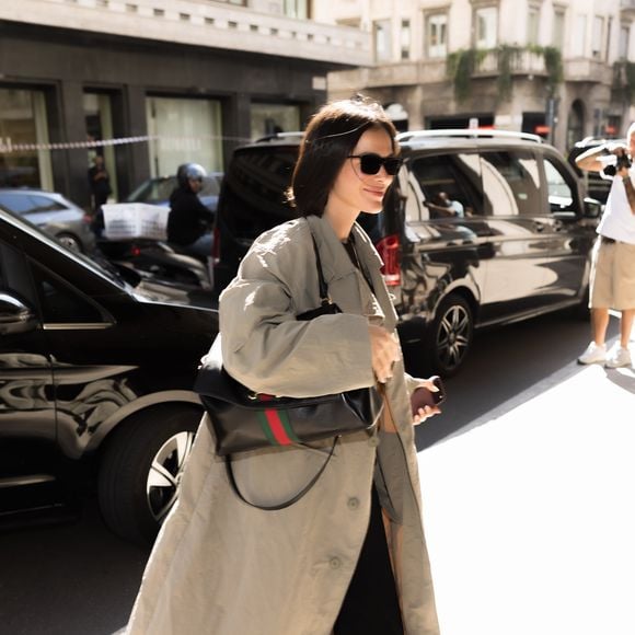 Bruna Marquezine apostou em um visual sofisticado e urbano durante sua passagem por Milão, com trench coat neutro, calça preta ampla, mocassim preto, óculos de sol e bolsa estruturada
