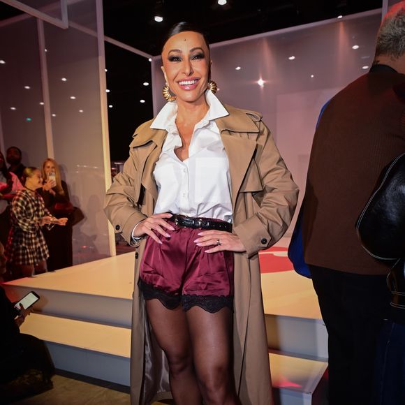 Sabrina Sato investe em combinação fashionista com camisa branca estruturada, trench coat e short de cetim com renda para prestigiar desfile de moda