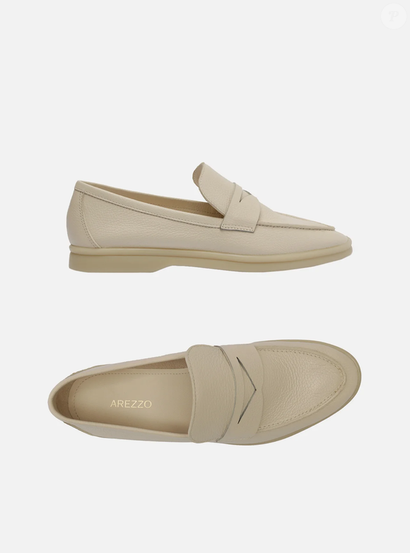 Com salto rasteiro, base bege e bico redondo, o modelo fechado traz recorte lateral na gáspea e aplicação de tira de couro vazada sobre o cabedal