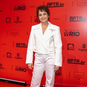 Drica Moraes: A atriz veste um conjunto monocromático off-white composto por uma jaqueta curta de alfaiataria estruturada com lapelas largas e botões frontais, combinada com calça reta de sarja no mesmo tom. Nos pés, ela opta por sapatos pretos fechados de bico arredondado