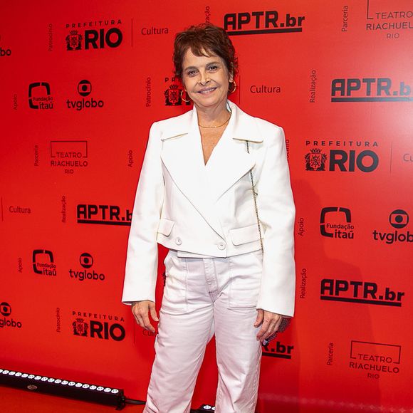 Drica Moraes: A atriz veste um conjunto monocromático off-white composto por uma jaqueta curta de alfaiataria estruturada com lapelas largas e botões frontais, combinada com calça reta de sarja no mesmo tom. Nos pés, ela opta por sapatos pretos fechados de bico arredondado