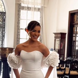 Emilly Araújo apostou em um vestido de noiva sob medida, com decote tomara que caia, busto estruturado e capa de flores artesanais para o ensaio pré-wedding com Davi Brito