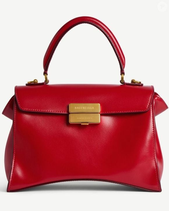 O look de Virginia foi complementado por bolsa de mão estruturada vermelha com fecho dourado e sapatos vermelhos de salto alto