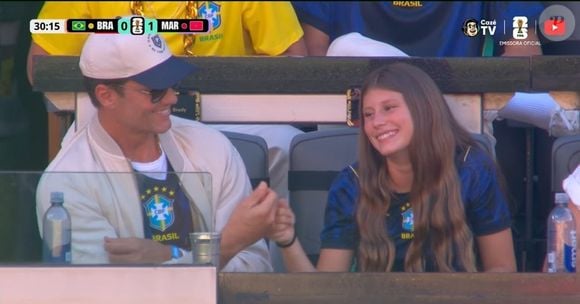 Vestindo a camiseta azul do Brasil, Vivian mostrou toda sua simpatia ao fazer um 'toque' com o pai para as câmeras da FIFA