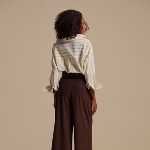 Com modelagem ampla e tecido estruturado, a peça alonga a silhueta e adiciona informação de moda ao look