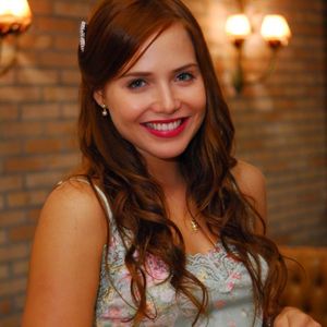 Letícia Colin já usou cabelo longo em tom castanho com aparência mais quente e reflexos avermelhados. O corte tem camadas suaves, comprimento em formato arredondado e uma franja longa que acompanha o contorno do rosto