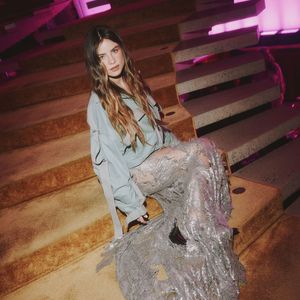 Giulia Be combina vestido de festa com jaqueta verde salva de R$ 11.484,09 em festa da NK Store com a grife The Attico, em São Paulo