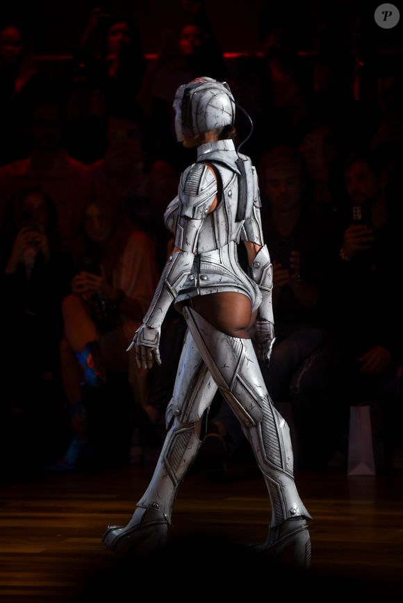 Com visual futurista, Deborah Secco desfila peça que mistura capacete, armadura metálica e recortes ousados, incluindo o bumbum à mostra.