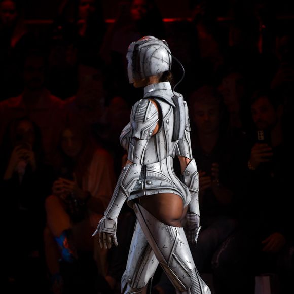 Com visual futurista, Deborah Secco desfila peça que mistura capacete, armadura metálica e recortes ousados, incluindo o bumbum à mostra.