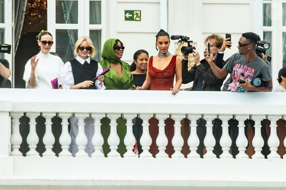 Mesmo com uma breve aparição, Kim reuniu uma multidão de fãs na calçada do hotel, que a receberam aos gritos e celulares em punho.