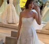4. Sereia em renda com sobre-saia e cauda: a mesma base do vestido sereia em renda floral, mas acompanhada de uma sobre-saia volumosa em tecido liso acoplada nas laterais da cintura. A peça adicional sobrepõe o quadril e se estende em uma cauda fluida e longa na parte posterior