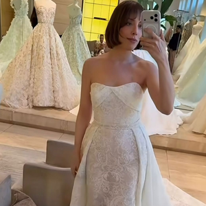 4. Sereia em renda com sobre-saia e cauda: a mesma base do vestido sereia em renda floral, mas acompanhada de uma sobre-saia volumosa em tecido liso acoplada nas laterais da cintura. A peça adicional sobrepõe o quadril e se estende em uma cauda fluida e longa na parte posterior