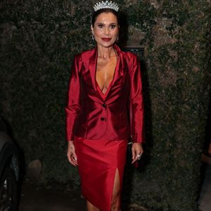 Flávia Alessandra: puro poder vilanesco! Flávia entregou uma auto-homenagem impecável ao reviver Cristina (Alma Gêmea). Ela surgiu radiante em um terno vermelho acetinado decotado, composto por blazer acinturado e saia lápis com fenda, arrematado por uma coroa de brilhantes e salto alto, exalando a pura aura da personagem