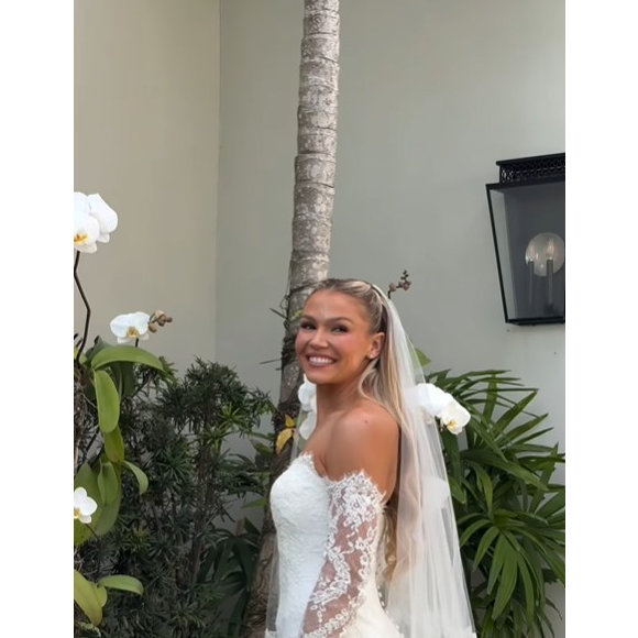 Carrie Lawrence, por sua vez, seguiu uma proposta mais clássica. A ex-zagueira usou um vestido longo branco com delicados detalhes em renda, combinado com véu e luvas.