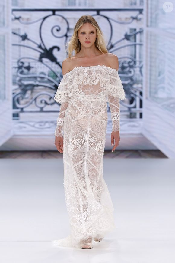 Vestido de noiva com decote ombro a ombro, renda e transparência: esta peça é ideal para noivas ousadas e românticas