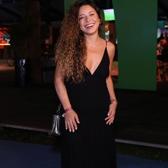 Maiara Queiroz: Exibindo um visual fluido e descomplicado, ela optou por um vestido longo preto de alças finas e decote em V bem pronunciado. A produção focou no caimento leve do tecido, complementada por uma minibolsa transversal prateada com acabamento metalizado e mix de acessórios discretos