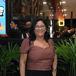 Dona Delma combinou blusa marrom com mangas bufantes e calça preta