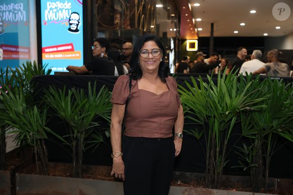 Dona Delma combinou blusa marrom com mangas bufantes e calça preta