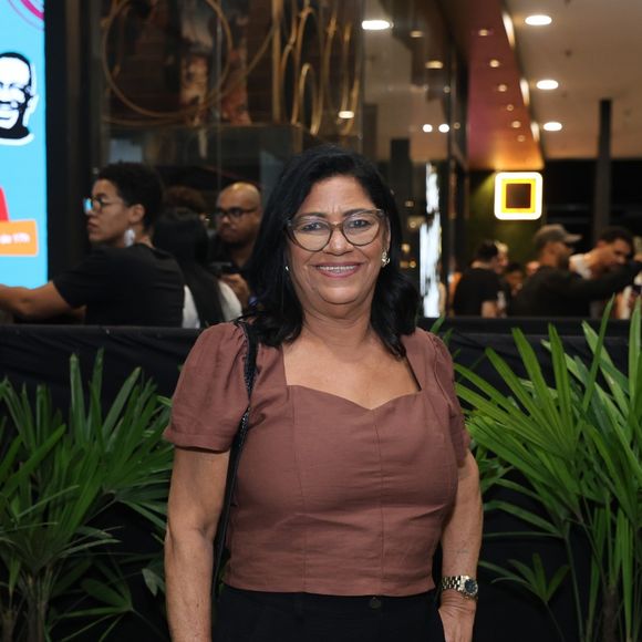 Dona Delma combinou blusa marrom com mangas bufantes e calça preta
