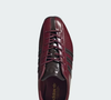Com tonalidade bordô escura e sofisticada, o tênis da Adidas ganha uma aparência que lembra um sapato social e pode compor produções mais elegantes