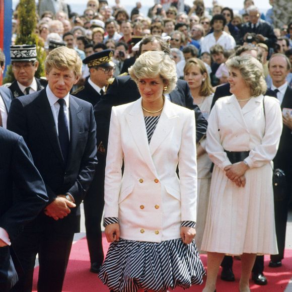 Em 1987, durante desembarque na Riviera Francesa, a eterna Princesa de Gales surgiu usando o modelo em uma produção assinada por Catherine Walker, composta por vestido mídi balonê listrado e blazer branco trespassado com ombros marcados