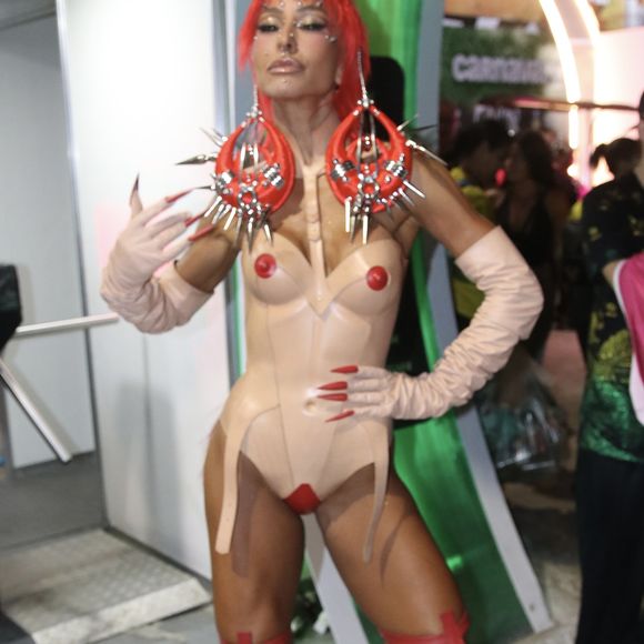 Sabrina Sato usou look com estruturas vermelhas com spikes nos ombros, dezenas de piercings falsos espalhados pelo rosto