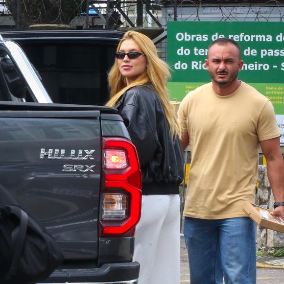 Nos pés, a escolha foi um scarpin branco de bico fino e salto alto, reforçando a elegância do visual e harmonizando com a calça clara.