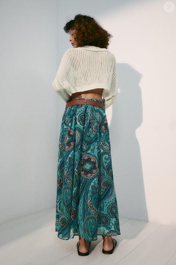 A Saia Estampada com Cinto da Zara, por R$ 359,00, reúne estampa azul e verde, shape amplo e cintura elástica em uma proposta que traduz a volta do boho chic. O cinto acompanha a peça e ajuda a definir a silhueta