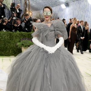 Sarah Paulson cruzou o tapete vermelho com um volumoso vestido de tule cinza e luvas brancas clássicas, surpreendendo a todos ao utilizar uma nota de dólar dobrada como uma máscara improvisada sobre os olhos