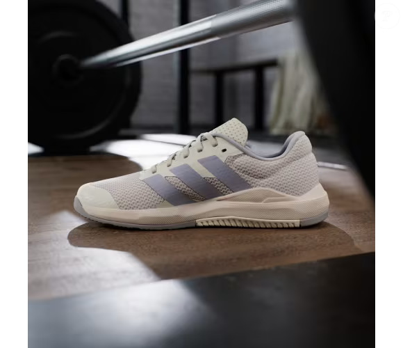 A combinação de legging preta e camiseta básica é uma das possibilidades para usar o Dropset Base, da Adidas, na cor cinza coala. A tonalidade neutra lembra a pelagem de um coala e permite montar uma produção esportiva discreta, enquanto o calçado foi desenvolvido para exercícios de treinamento de força