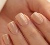 Base nude e camada fina de glitter dourado: a combinação transforma o clássico em opção festiva sem perder a elegância do neutro